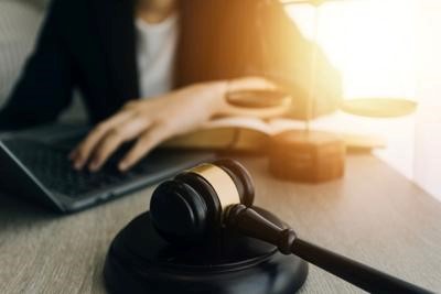 law books and scales of justice on desk in library of law firm